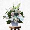 White and blush floral arrangement in a gray vase