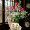 Red roses in a glass vase with a teddy bear and chocolate box