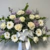 White roses and daisies in a white basket with a silver bow