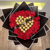 Heart-shaped bouquet of red roses with gold-wrapped chocolates and a black ribbon