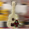 Tall guitar-shaped floral tribute in white with red roses and gold string accents