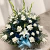 Fan-shaped white roses, carnations, and lilies with blue accents and a light blue bow.