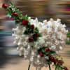 Heart-shaped standing spray of ivory roses with red roses accent on a metal easel.