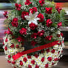 Large red and white funeral wreath with roses, lilies, and carnations on a standing frame