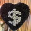 Heart-shaped black floral standing spray with silver carnations forming a dollar sign.