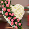 Heart-shaped standing spray of white mums with cascading pink roses on one side
