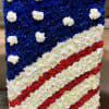 Rectangular floral American flag arrangement with blue, red, and white flowers.