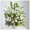 Tall arrangement of white lilies and roses with green Bells of Ireland in a white basket.