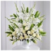Large white and cream floral arrangement with roses and lilies in a white pedestal vase