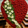 Large heart-shaped standing spray of red roses with a diagonal cascade of white lilies.