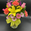 A cheerful burst of sunshine! This vibrant bouquet features pink roses, coral