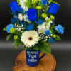 Blue and white mixed flower arrangement in a blue best dad mug on a wooden base