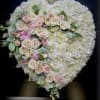 Heart-shaped white hydrangea wreath with cascading blush and pink roses.