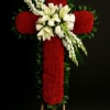 Standing red floral cross with white lilies and roses on a wooden easel