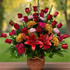 Red roses and lilies arranged in a decorative vase