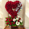 Heart-shaped red rose arrangement with white daisies and butterfly accents