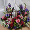 Colorful floral arrangement surrounding a silver urn