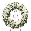 White floral wreath on a black easel stand
