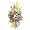 A graceful standing spray featuring a soft blend of yellow, pink, and