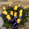 Yellow roses and purple daisies in a glass vase with a purple ribbon