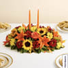 Low floral centerpiece with orange candles and mixed autumn blooms