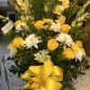 Yellow and white floral arrangement with a large yellow ribbon in a white vase