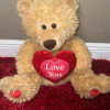 Teddy bear holding a red heart that says "Love You"