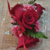 Red rose corsage with pink carnations in a clear plastic box
