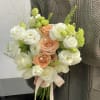 Bouquet of white and peach roses with pale green accents and ribbon