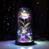 Glowing artificial flower under a glass dome with multicolor lights