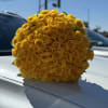 Large bouquet of yellow roses resting on a car hood