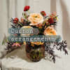 Peach and red floral arrangement in a glass vase