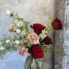 Bouquet of red roses and pink carnations in a clear glass vase