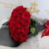 Bouquet of red roses wrapped in black paper with a red ribbon