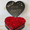Heart-shaped box of red roses with a Happy Anniversary sign