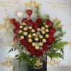Heart-shaped rose arrangement with gold-wrapped chocolates in a black box