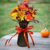 Autumn bouquet in a black vase with a red ribbon