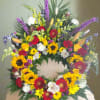 Colorful funeral wreath with sunflowers, roses, and lilies on a casket