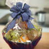 Fruit basket wrapped in clear cellophane with a blue ribbon