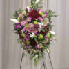 Large standing floral spray with pink, purple, white, and red blooms