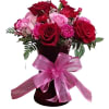 Red and pink roses in a dark vase with a pink ribbon bow