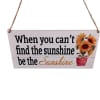 Hanging wooden sign with sunflowers and the phrase "be the Sunshine"