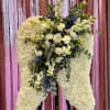 Large white floral standing spray on an easel with blue accents
