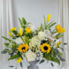 Yellow tulips and white roses arranged in a gray vase