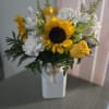 A cheerful  mix of sunflowers, white carnations, and yellow roses and