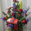 Red roses, red carnations, blue delphiniums, assorted greenery.Decorative paper truck, Spider-Man cutout