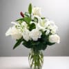 A graceful arrangement of white roses, lilies, and carnations with fresh greenery