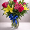 vibrant arrangement featuring hot pink roses, bright yellow lilies, and pink alstroemeria