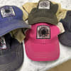Five embroidered baseball caps in assorted colors with sunflower patches