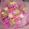 Bouquet of pink and cream roses with bright pink filler and gold butterfly decorations